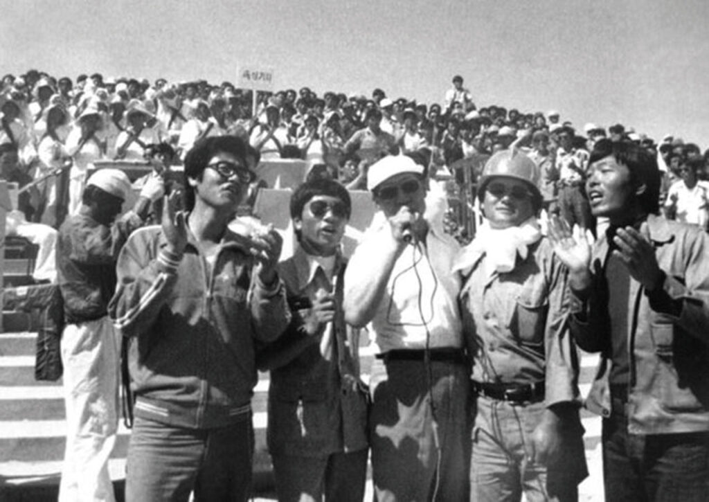 1978년 현대건설의 중동 현장을 방문한 정주영 회장(가운데)이 노동자와 함께 노래하고 있다.ⓒ아산정주영닷컴 제공